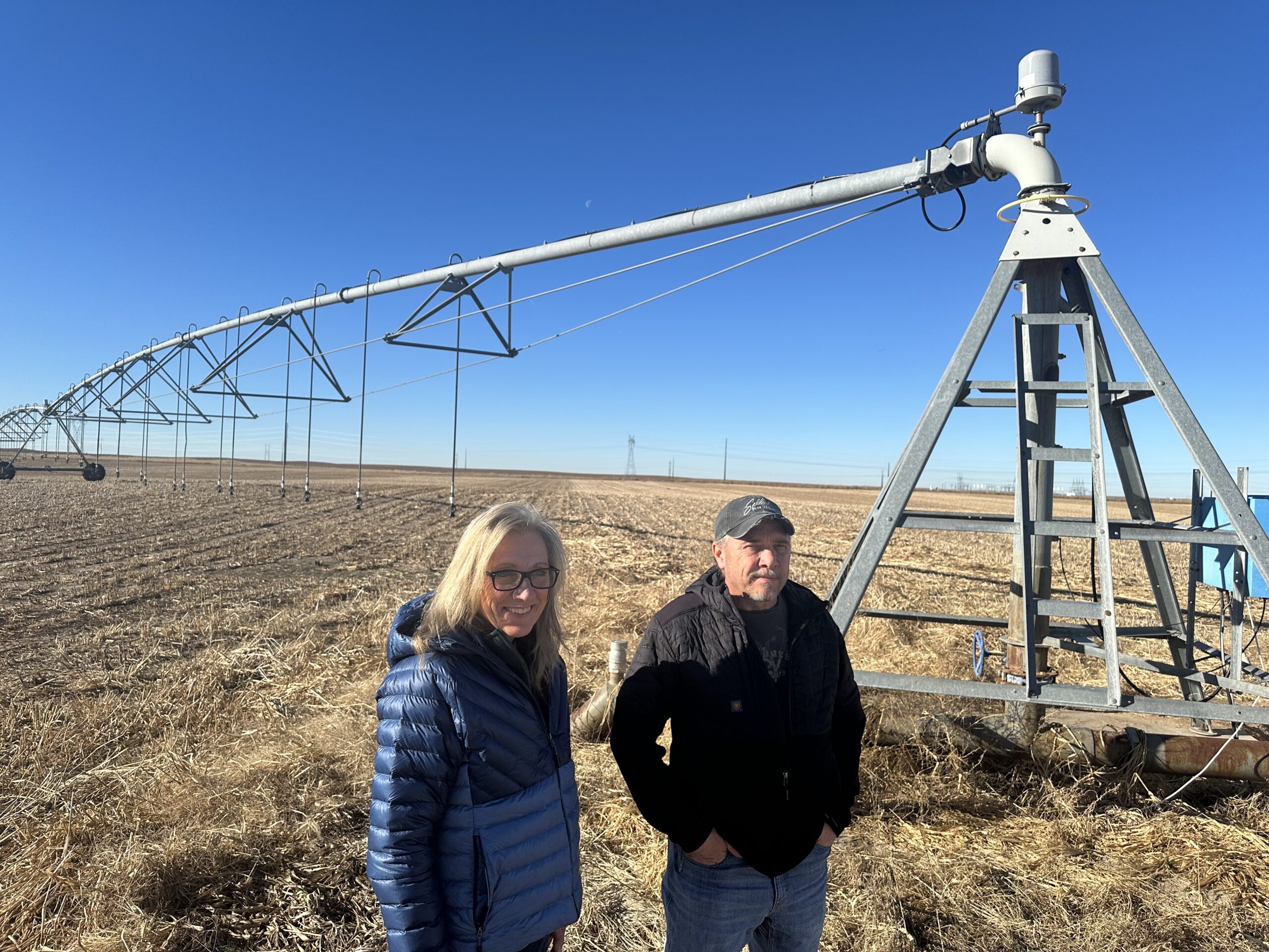 Gina and Marc Gigot beside irrigation equipment on their farm near Garden City. File photo published in January 2024.